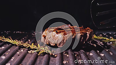 Delicious juicy meat steak cooking on grill. Aged prime rare roast grilling marble beef. Electric roaster, rosemary Stock Photo