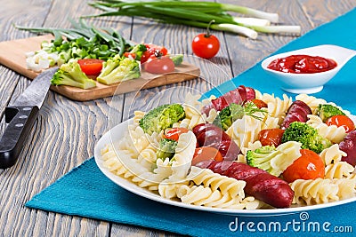 Delicious l Pasta salad with broccol, tomatoi and grilled sausa Stock Photo