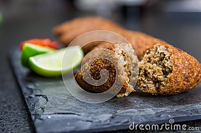 Delicious Lebanese food, kibbeh kibe on black slate stone and granite background Stock Photo