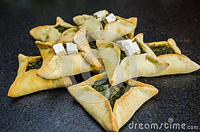 Delicious Lebanese food, spinach sfiha with ricotta cheese on black stone background Stock Photo