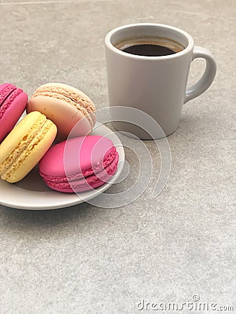 Delicious macaroons and cup of coffee on gray table Stock Photo