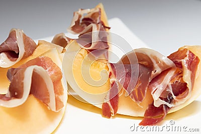 Melon with thin slices of cured ham on a plate Stock Photo