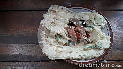 Delicious mendoan on plate and hot sauce traditional food from banyumas indonesia made from fried tempe on brown wood background Stock Photo