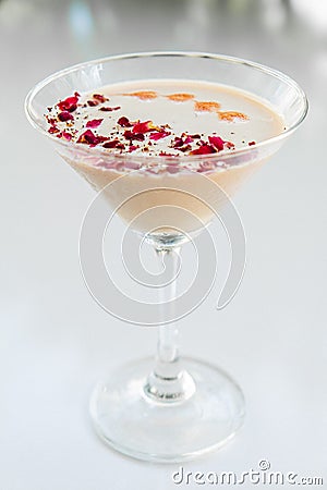 Milky rose cocktail with red petals Stock Photo