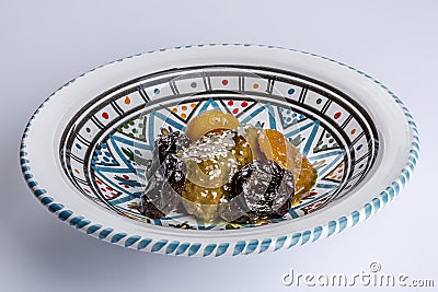Delicious moroccan sweet dessert with prunes and dried apricots on a white ceramic plate with multicolor decoration Stock Photo