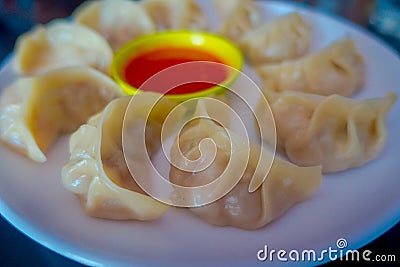 Delicious Nepali traditional snack, chicken MoMo serve with spicy and sour sauce in a white plate Stock Photo