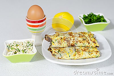 Delicious omelet with cheese, zucchini and greens filling Stock Photo