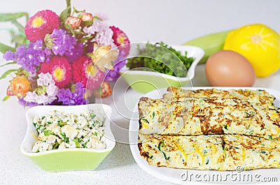 Delicious omelet roll with cheese and zucchini filling on a white table Stock Photo