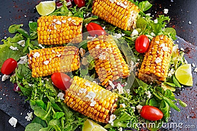 Delicious oven cooked Corn with feta cheese, paprika, lime, vegetables. Stock Photo