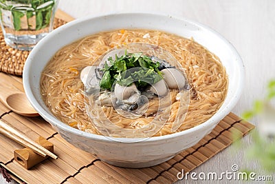 Delicious oyster vermicelli in a bowl on wooden table background Stock Photo