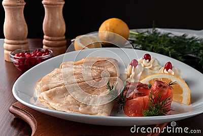 Delicious pancakes with red fish, lemon and cranberries on a white plate, table served in restaurant in rustic style, concept of Stock Photo