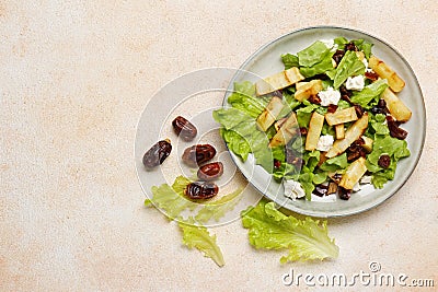 Delicious parsnip with lettuce, feta cheese and dates on beige table, flat lay. Space for text Stock Photo