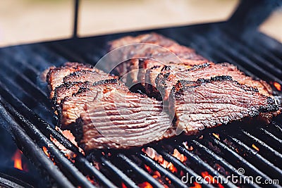 Delicious pieces of meat with barbecue sauce on smoker grill Stock Photo