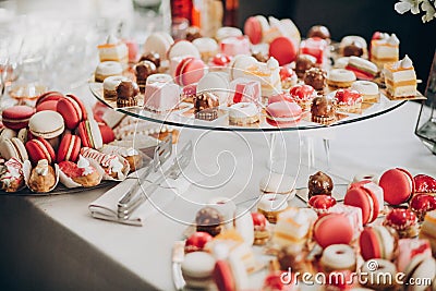 Delicious pink candy bar at wedding reception or christmas celebration. Pink and white macarons,cupcakes, desserts on stand, Stock Photo