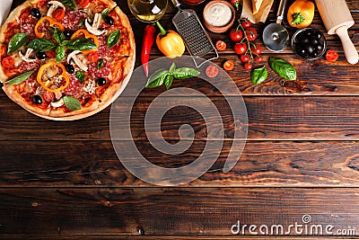 Delicious pizza and ingredients on wooden background Stock Photo