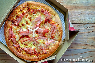 Delicious pizza with pineapple, ham slice, bacon slice, mozzarella cheese, pizza sauce in a delivery box Stock Photo