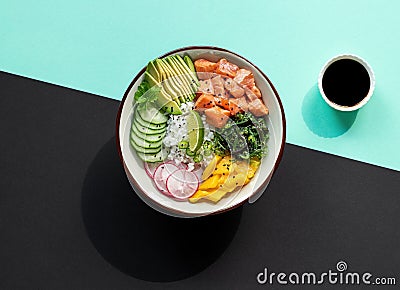 Delicious poke bowl with rice, mango, avocado, radish, chukka salad, cucumber, and marinated fresh salmon. Stock Photo