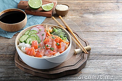 Delicious poke bowl with salmon and vegetables served on wooden table. Space for text Stock Photo
