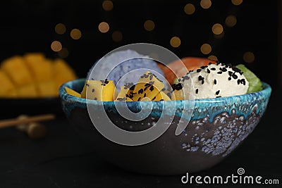 Delicious poke bowl on table against blurred lights, closeup Stock Photo