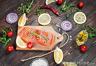 Delicious portion of fresh salmon fillet with aromatic herbs, spices and vegetables - healthy food, diet or cooking concept. Stock Photo