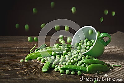 Delicious ripe green peas lying on a wooden table. Stock Photo