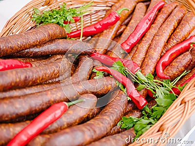 Delicious sausages and red hot peppers in a basket Stock Photo