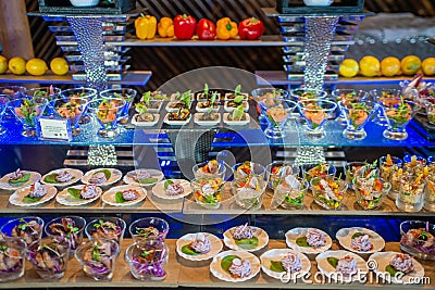 Delicious short eats arranged on the desk in the small glass bowls in the buffet Editorial Stock Photo