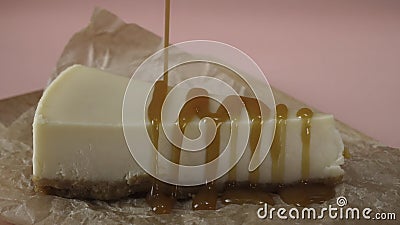 Delicious slice of cheesecake, which is pouring by thin stream of caramel sauce. Frame. Close-up Stock Photo