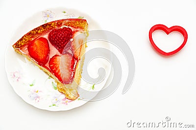 Delicious slice homemade strawberry tart with heart-shaped object on the side. Stock Photo