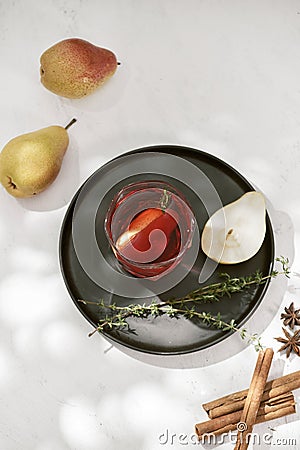 Delicious spicy hot mulled red wine with cinnamon, star anise and slice pear served in a carafe and glass for a cold winter Stock Photo