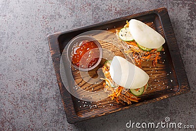 Delicious steamed bao buns sandwiches with pulled pork close-up on a wooden tray. horizontal top view Stock Photo