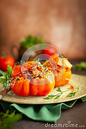 Delicious stuffed tomatoes in shape of pumpkin with rice, vegetables and meat. Concept homemade healthy eating Stock Photo