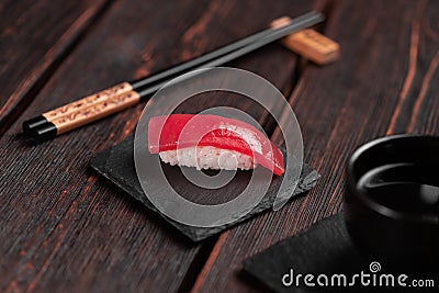 Delicious sushi maguro tuna. Nigiri with tuna on black and wooden background . Traditional Japanese cuisine Stock Photo