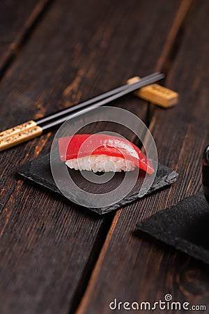 Delicious sushi maguro tuna. Nigiri with tuna on black and wooden background . Traditional Japanese cuisine Stock Photo