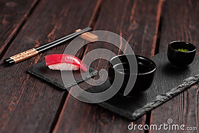 Delicious sushi maguro tuna. Nigiri with tuna on black and wooden background . Traditional Japanese cuisine Stock Photo