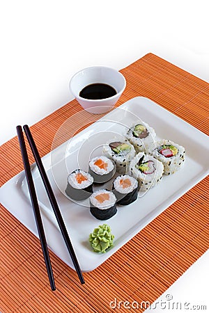 Delicious sushi rolls on white plate with chopsticks Stock Photo