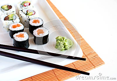 Delicious sushi rolls on white plate with chopsticks Stock Photo