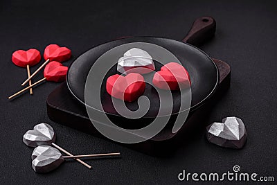 Delicious sweet heart shaped chocolate candies on a dark concrete background Stock Photo