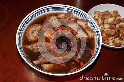 Home made delicious and tasty Bah Kut Teh pork rib soup served with stir ice salad and fried onion plus fired bread. Stock Photo