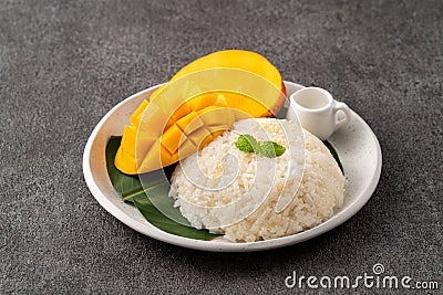 Delicious Thai mango sticky rice with cut fresh mango fruit in a plate Stock Photo