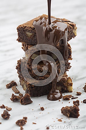 Tower of classic chocolate brownies with walnuts and melted chocolate Stock Photo