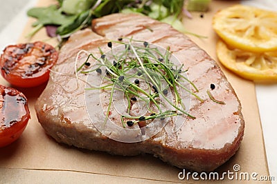 Delicious tuna steak with microgreens on parchment paper Stock Photo