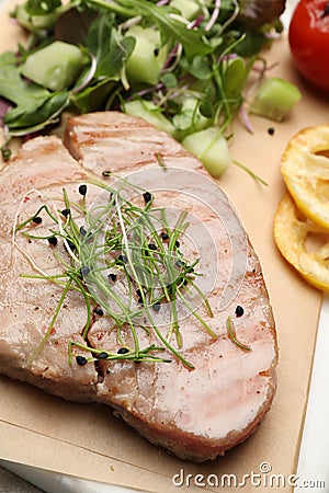 Delicious tuna steak with microgreens on parchment paper, closeup Stock Photo