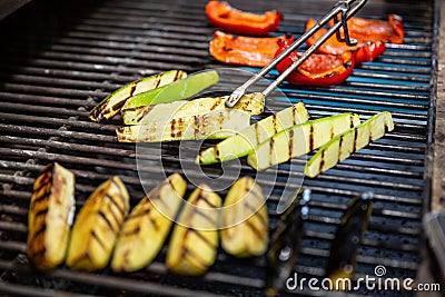 Delicious vegetables grilling in open grill, outdoor kitchen. food festival in city. tasty food peppers zucchini roasting on baske Stock Photo