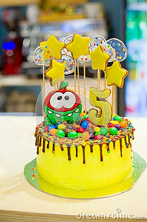 Delicious yellow cake for the birthday of a 5-year-old child, yellow stars and transparent candies on the cake, the number 5 Editorial Stock Photo