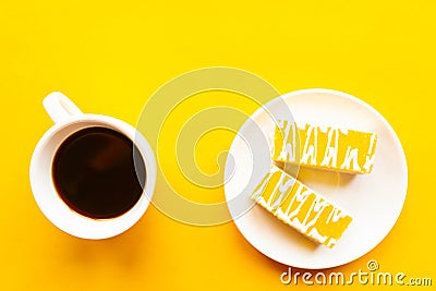 Delicious yellow cakes on a plate and coffee cup, top view. Bright yellow background Stock Photo