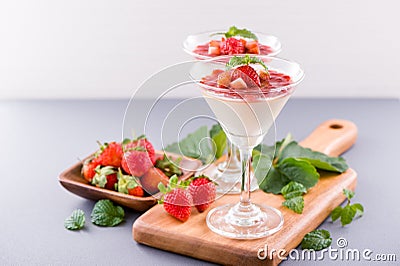 Delicous and nutritious double color colour strawberry desserts with mint and diced sarcocarp topping isolated with airy blue Stock Photo