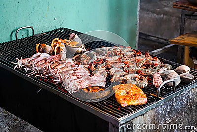 Delicous seafood grilling on ember stove close up. Street food at night in Vietnam Stock Photo