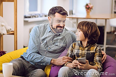 Delighted bearded man hugging his son Stock Photo