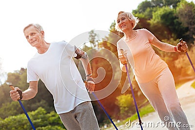 Delighted elderly couple practicing Nordic walking Stock Photo